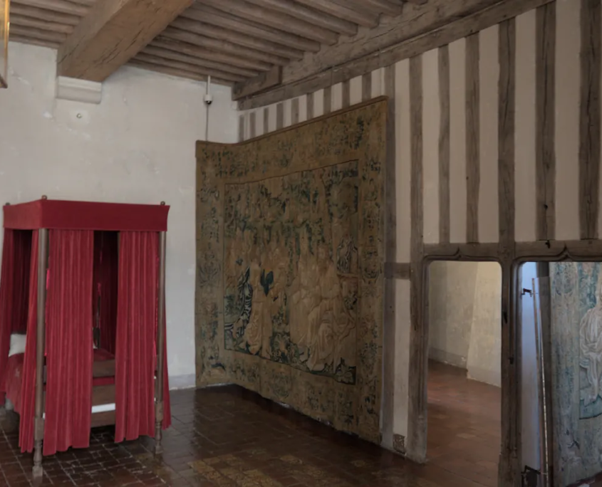 Slaapkamer in het kasteel van Chateauneuf en Auxois met een bed en een wandtapijt